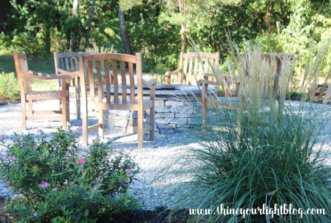 A DIY pea stone patio with stone fire pit.