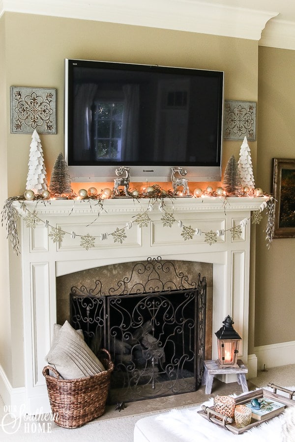 A Christmas fireplace with a TV over the mantle by Our Southern Home.